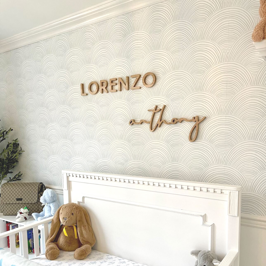 blue boy room with wooden name sign above crib