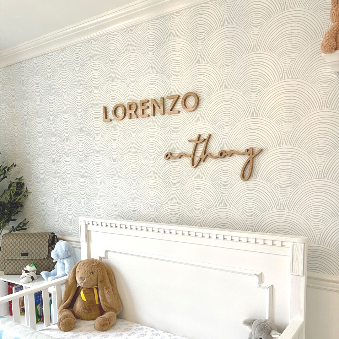 blue boy room with wooden name sign above crib