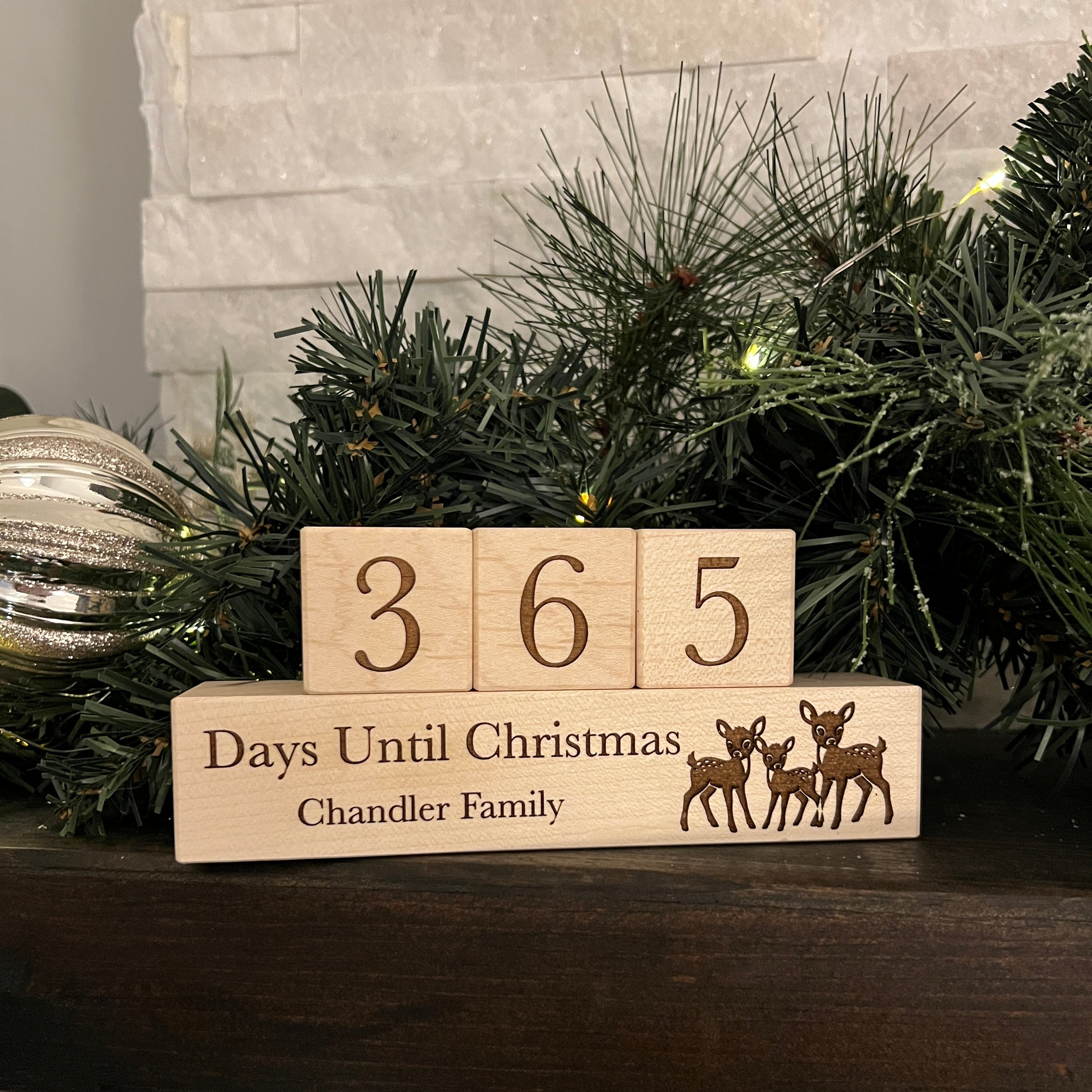 Wooden blocks with '365 Days Until Christmas' and family name on a Christmas tree.