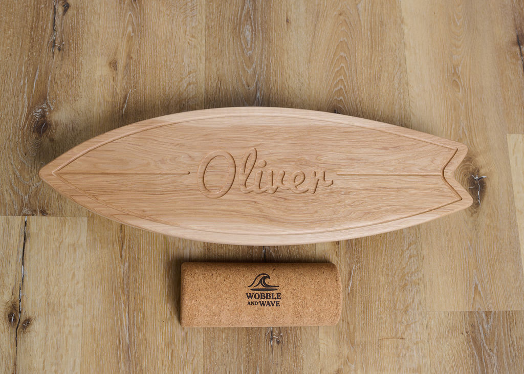 Wooden balance board with 'Oliver' engraving on a wooden surface, accompanied by a cork Wobble and Wave block. Durable hickory balance board customized with a cursive name. Perfect for balance play, fitness, and personalized room decor.