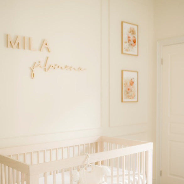 white nursery for baby girl with personalized name sign above crib