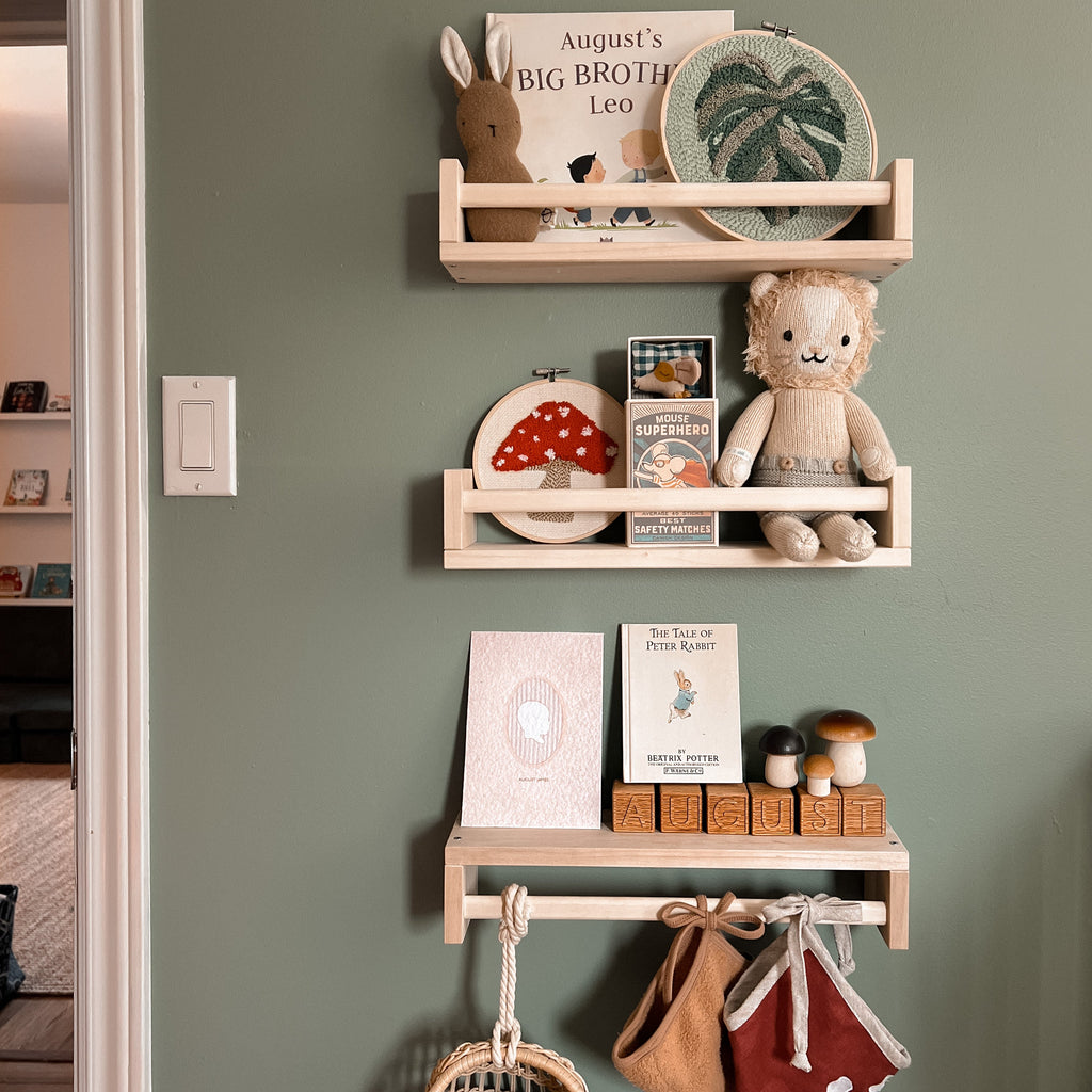 Calming sage green nursery featuring red oak baby blocks from Timberwood Designs, styled with nature and mushroom-themed decor. The warm wood tones complement the earthy color palette, creating a cozy and whimsical environment.