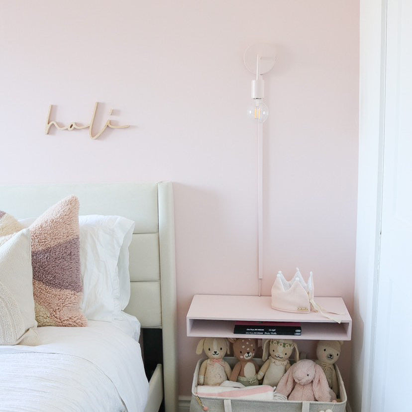 wooden sign above girl bed