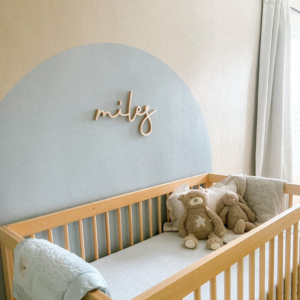 boy nursery design with blue arch and wooden name sign