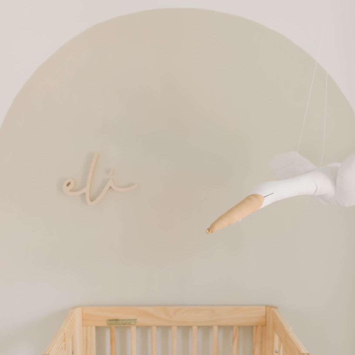 wooden name sign above crib in arch