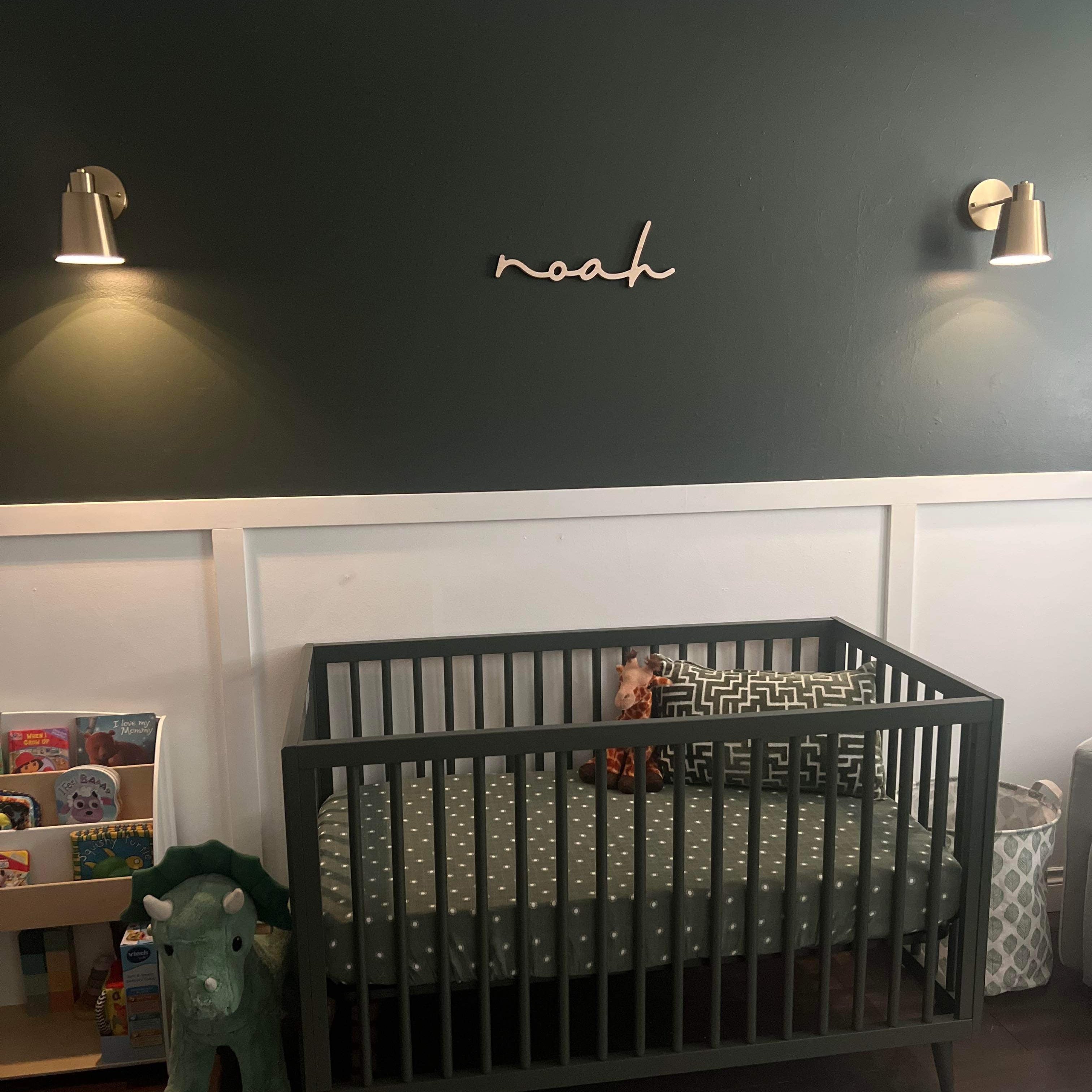 deep coloured nursery with name sign above crib