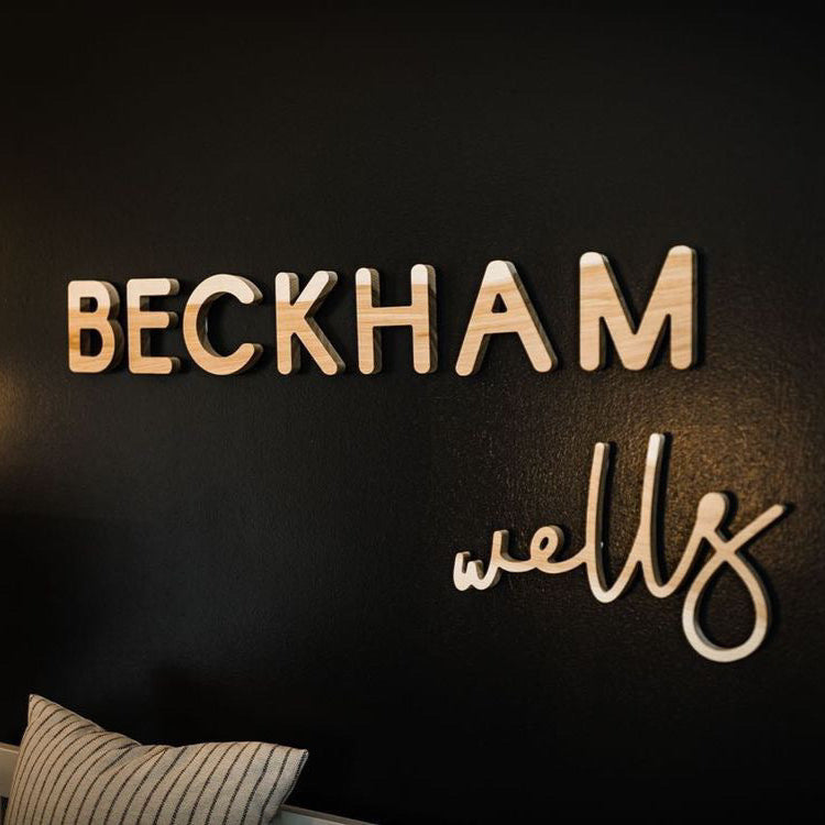 boy nursery design with black walls and wooden name sign 