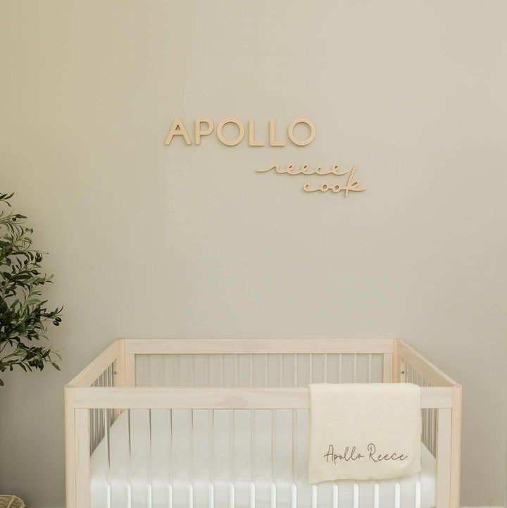 boy nursery in parent bedroom with wooden name sign 