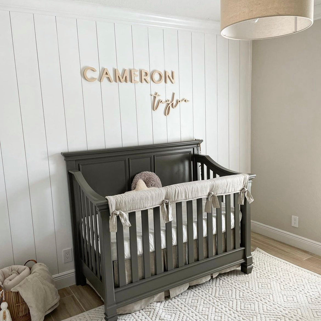 wooden name sign above crib in boy nursery