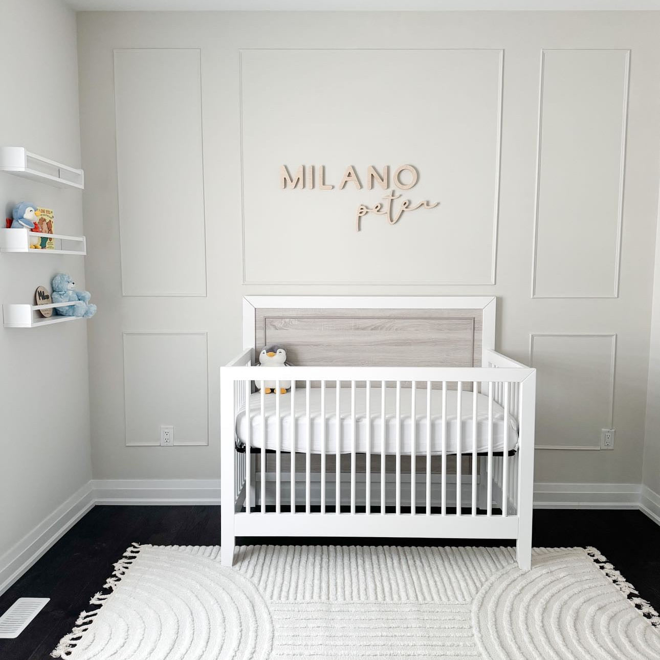 wooden name sign above boy nursery crib