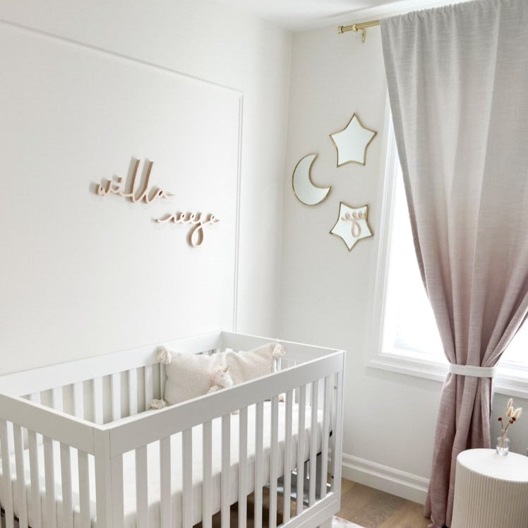 girl name sign above crib in white nursery