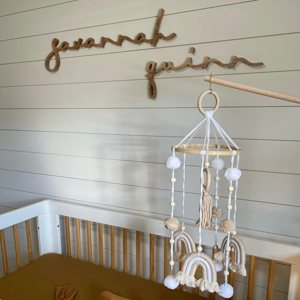 girl nursery decor with wooden name sign on shiplap
