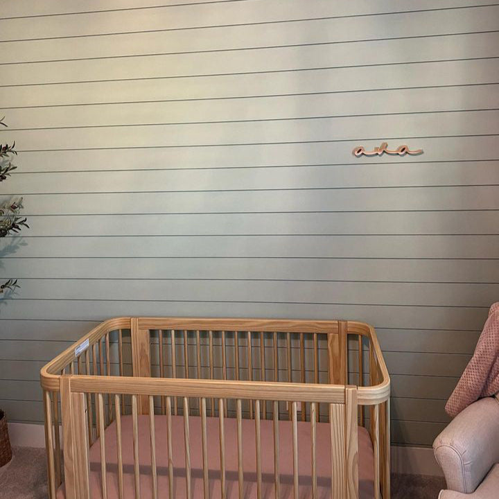 girl nursery with shiplap and wooden name sign