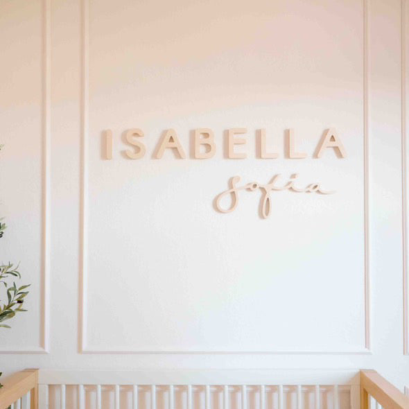 wood name sign in girl nursery with feature wall