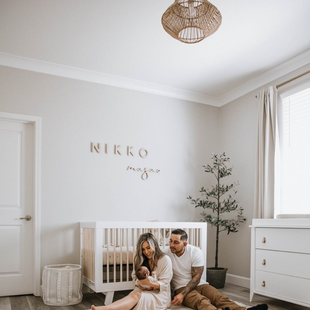 Neutral boy nursery with Nursery Name Sign above crib