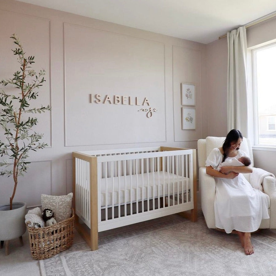 pink girl nursery, with board and batten design and a wooden name sign