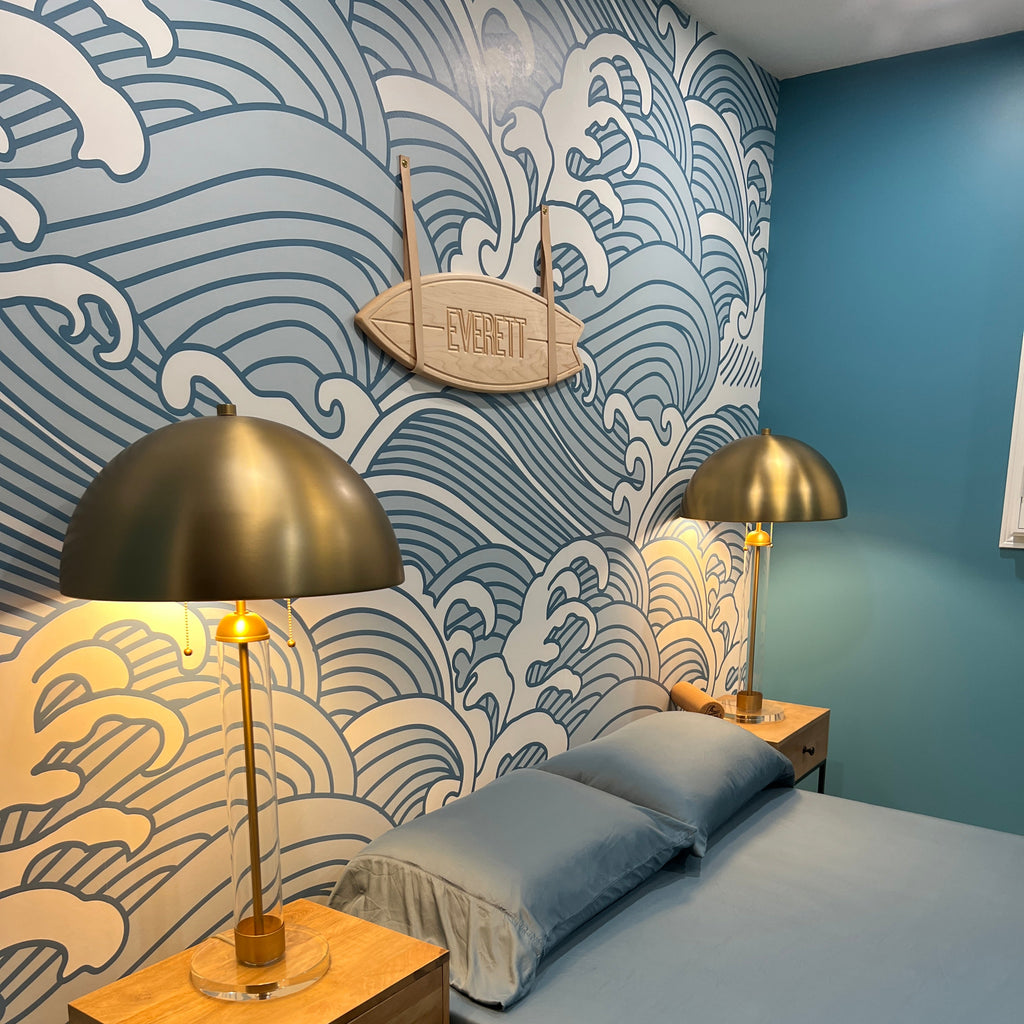 Gold and wooden table lamps on a patterned surface with a blue wall in the background