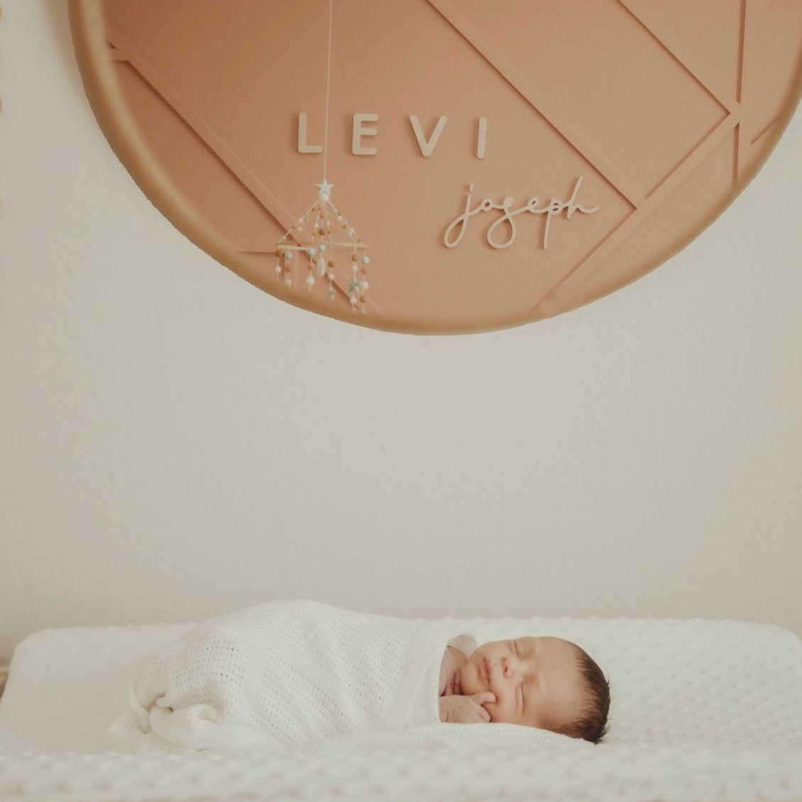 newborn nursery with name sign display in the mirror