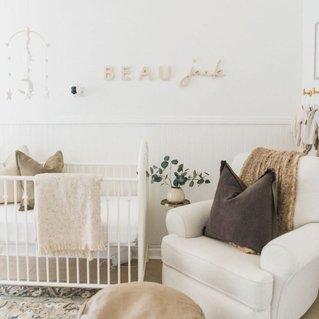 White Nursery with Wooden Nursery Name Sign above crib